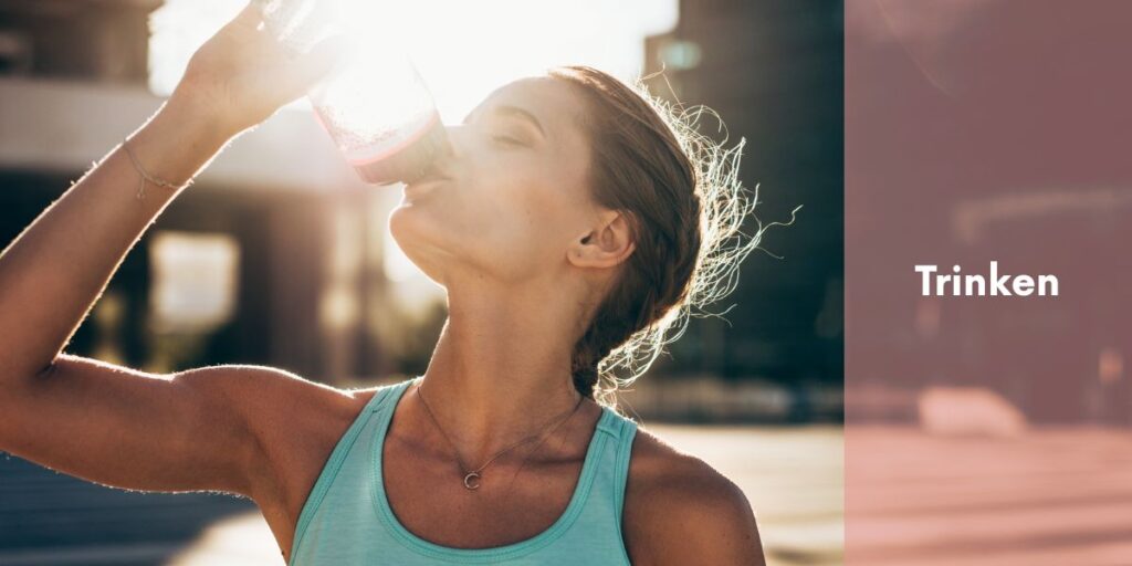 Sportlerin trinkt bei Sonnenuntergang aus einer Sportflasche – Symbolbild für vegane Trinkstrategie für Sportler:innen zur optimalen Flüssigkeitszufuhr beim Training.